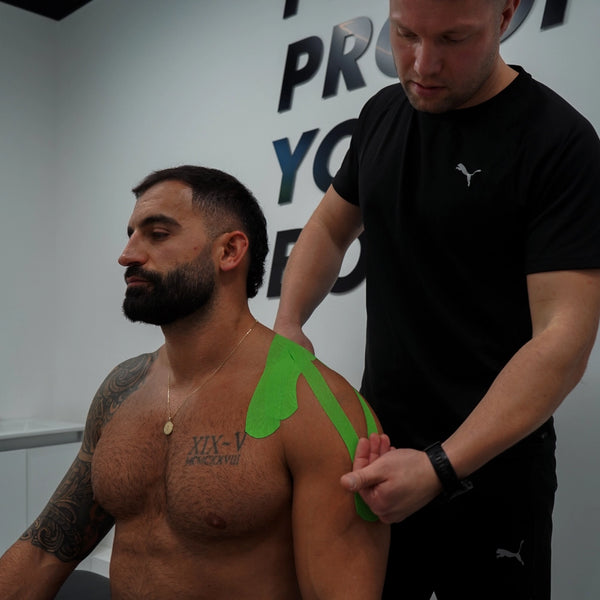 Green K-Tape kinesiology tape on mans shoulder