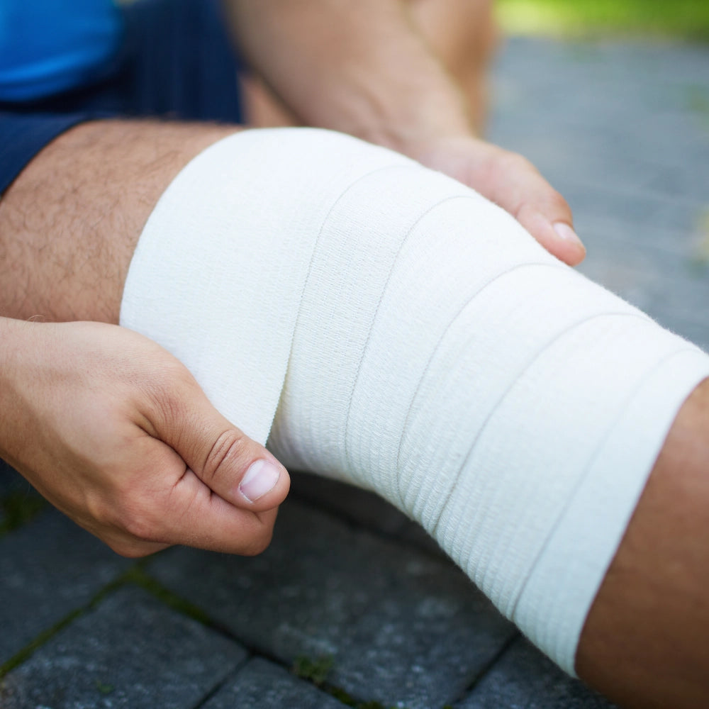 White, textured medical bandage wrapped snugly around a knee.